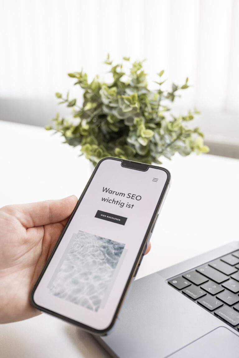 Hand mit IPhone - am Hady ist der Text "Warum SEO wichtig ist" abgebildet